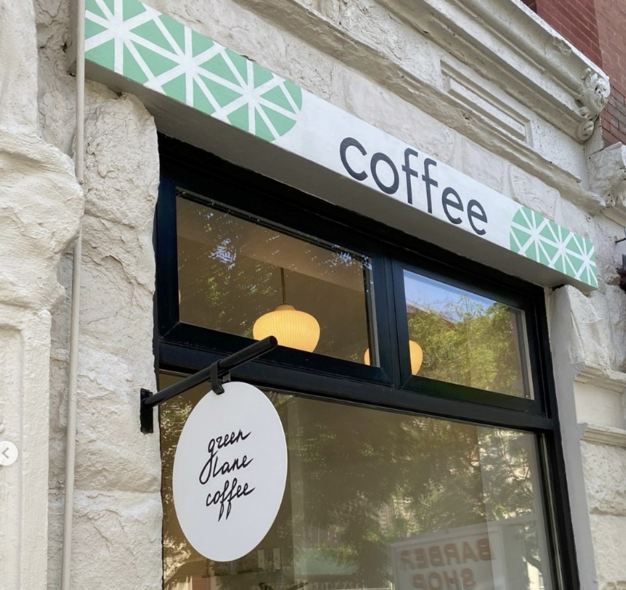 The Green Lane Coffee storefront sign and coffee lettering above the entrance